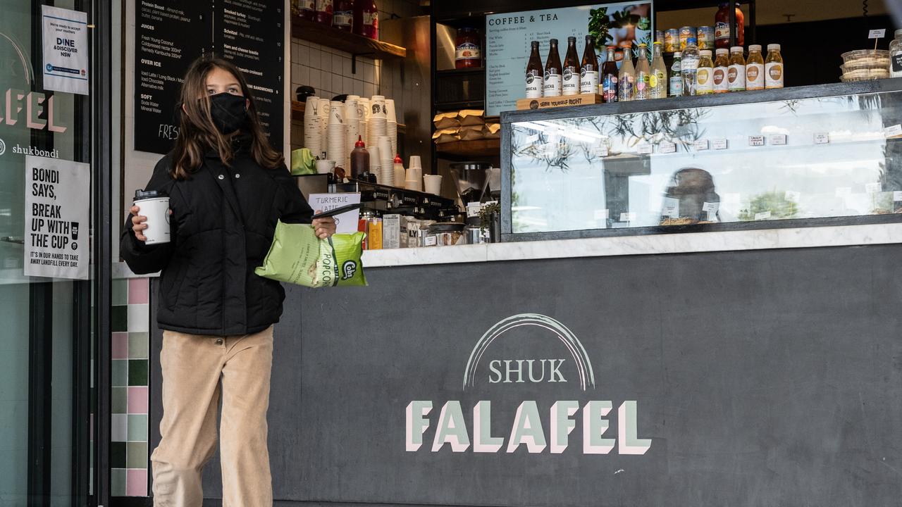 A customer outside a coffee shop that has swapped to takeaway only in line with new COVID-19 lockdown restrictions. Picture: NCA NewsWire / James Gourley