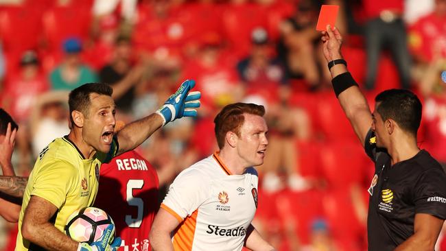 Michael Theo of Brisbane Roar reacts after receiving a red card from referee Stephen Lucas.
