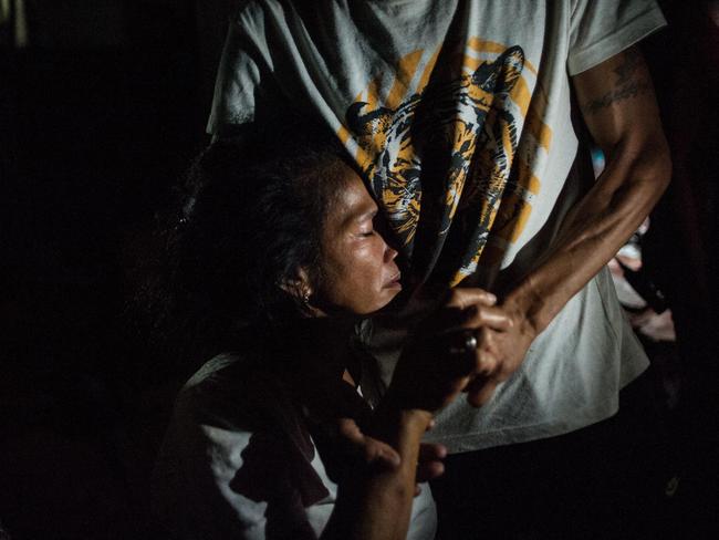 A mother of a victim of a summary execution clutches a man upon learning of her son’s death in Manila last week. Picture: Dondi Tawatao/Getty Images