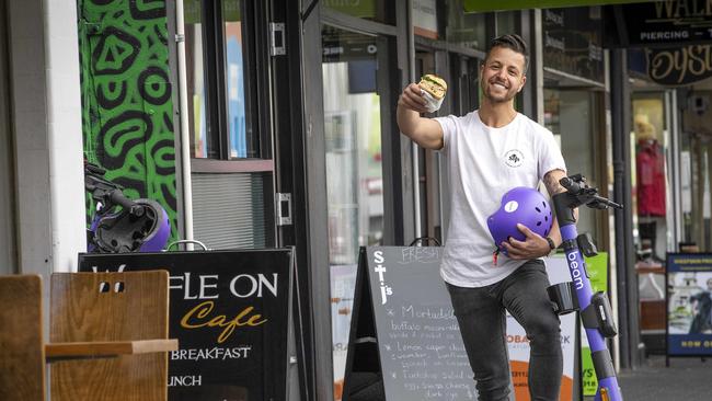 St. J's Deli owner Ben Korkmaz as part of the Beam e scooter trial at Hobart. Picture: Chris Kidd