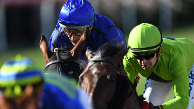 Damien Oliver (second from left) rides Happy Clapper alongside Royal Symphony, ridden by Dean Yendall, during the Cox Plate on Saturday.