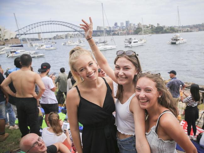 Caroline Pustinova, Maike Glogger and Florentina, from Germany, in position at Mrs Macquarie's Chair for tonight's New Years Eve celebrations in Sydney. Picture: Dylan Robinson