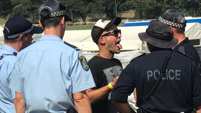 Police question a man at the Electric Garden festival in Centennial Park.