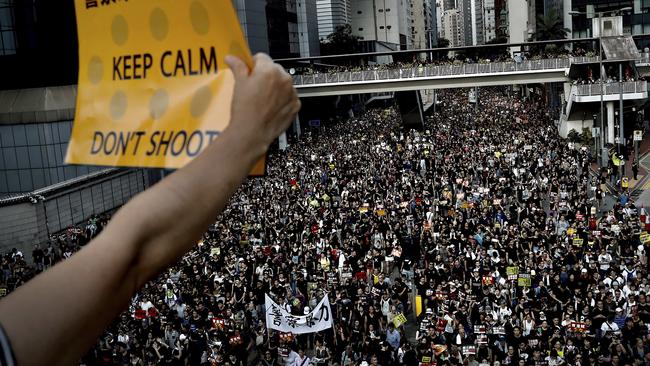 A protester holds up a placard as protesters flood the streets. Picture: AP