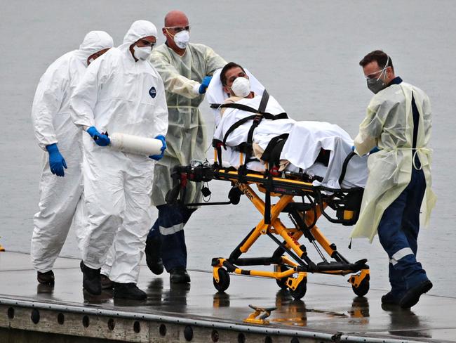 Ruby Princess staff member being evacuated while surrounded by police and medical staff on April 2. Picture: Adam Yip/The Australian