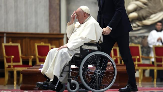 Pope Francis touches his forehead in acknowledgment of the cardinal. Picture: Getty