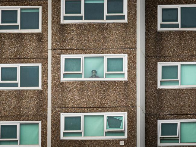 Life in lockdown. A lone woman is seen looking out the window of her apartment at the North Melbourne Public housing flats on July 5 in Melbourne. Before long all Victorians would be in a similar situation. Picture: Getty