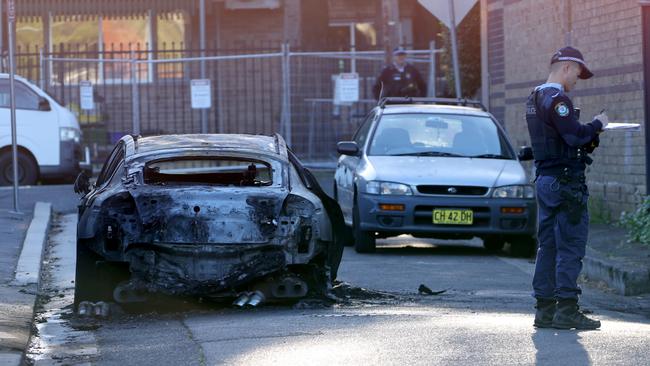 The burnt out Kia Stinger, the first getaway car, is examined by police. Picture: NCA NewsWire / Damian Shaw