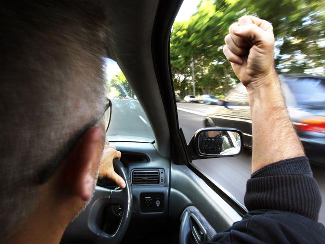 Generic pic of a motorist inside his car as he shakes his fist at passing vehicles.