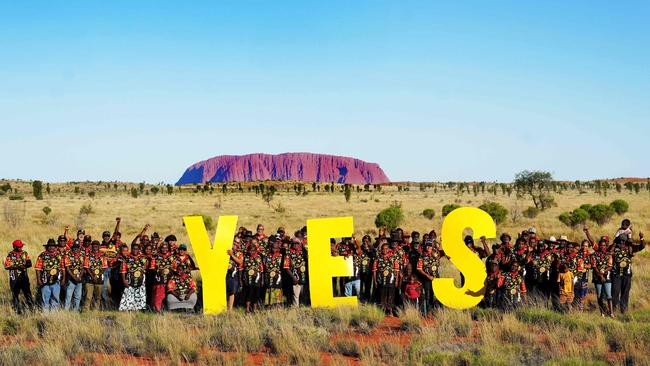 Grassroots representatives of remote communities in Central Australia posing in front of Uluru after their council meeting to vote 'Yes' to a Voice to Parliament. Picture: Tina Tilhard