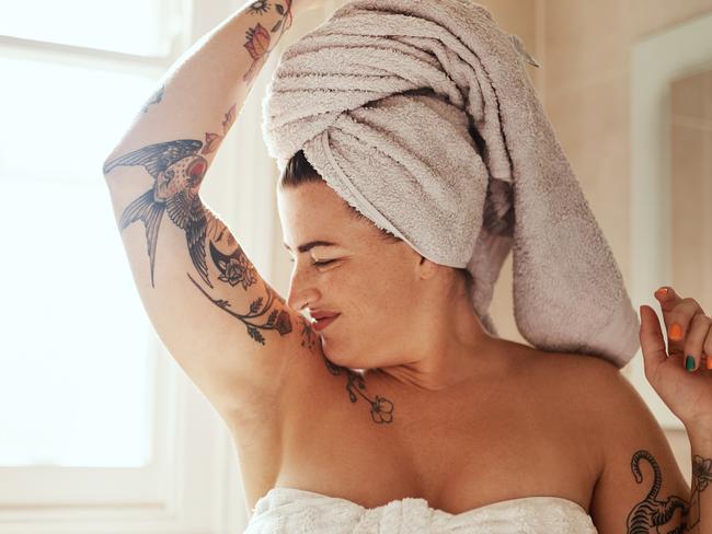 Shot of an attractive young woman smelling her armpits during her morning beauty routine