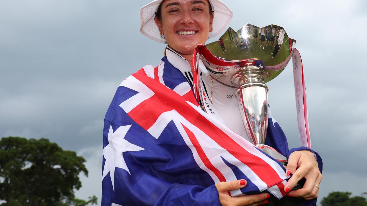 SINGAPORE, SINGAPORE - MARCH 03: Hannah Green of Australia poses with the trophy on the 18th green whilst wearing the Australian flag following victory on Day Four of the HSBC Women's World Championship at Sentosa Golf Club on March 03, 2024 in Singapore. (Photo by Andrew Redington/Getty Images)