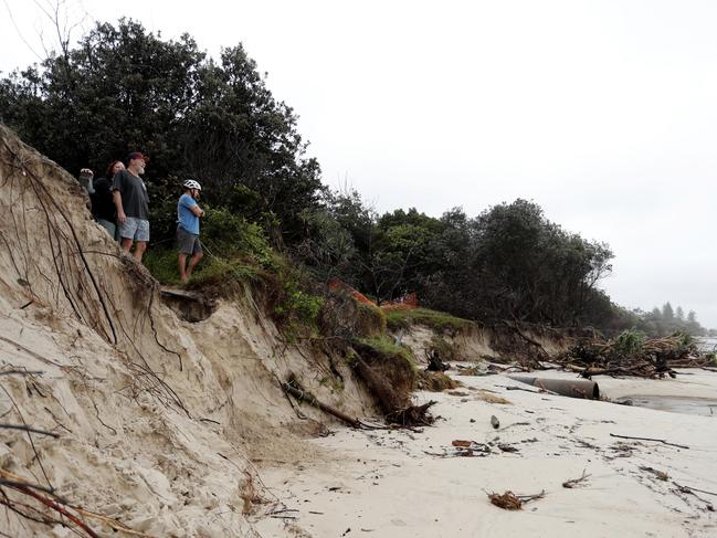 BYRON BAY, AUSTRALIA - DECEMBER 14:  People watch the long stretch of coastal areas seen disappeared due to erosion along the beach side, December 14, 2020 in Byron Bay, Australia. Byron Bay's beaches face further erosion as wild weather and hazardous swells lash the northern NSW coastlines. (Photo by Regi Varghese/Getty Images)