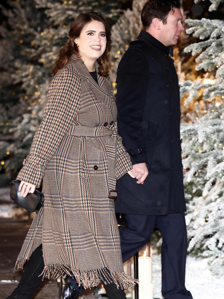 Princess Eugenie and her husband Jack Brooksbank arrive with Eugenie also in a checked coat. Picture: Henry Nicholls/AFP