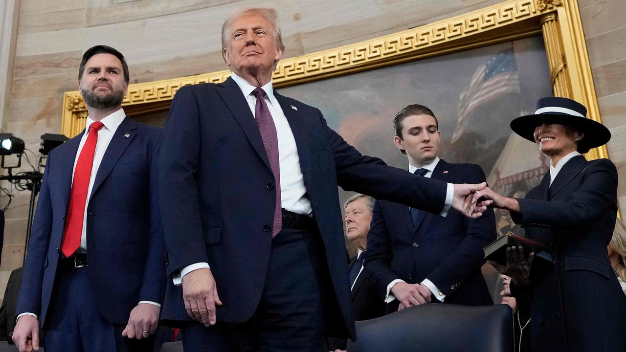 US President Donald Trump holds the hand of his wife Melania Trump as their son Barron looks on. Picture: AFP