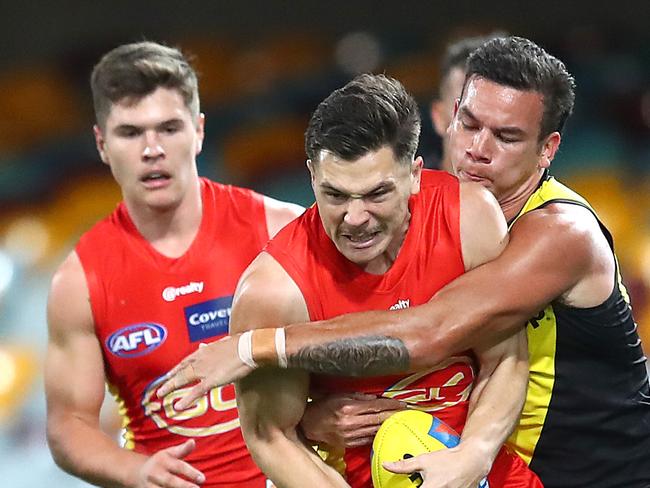 BRISBANE, AUSTRALIA - AUGUST 17: Ben Ainsworth of the Suns is tackled during the round 12 AFL match between the Richmond Tigers and the Gold Coast Suns at The Gabba on August 17, 2020 in Brisbane, Australia. (Photo by Jono Searle/AFL Photos/via Getty Images)