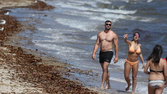 Beachgoers brave the conditions at Albert Park beach on Friday. Picture: Stuart MIliigan