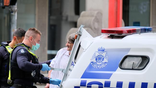 . A man is questioned, checked and detained by police in Melbourne as the state is locked down. Picture : NCA NewsWire / Luis Ascui