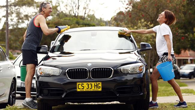 Ingo Susing (left) and Lana Ledgerwood in Cremorne washing their car the correct way with buckets only. Picture: Sam Ruttyn