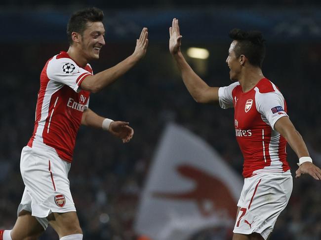 Arsenal's Chilean striker Alexis Sanchez (R) celebrates scoring his goal with Arsenal's German midfielder Mesut Ozil (L) during the UEFA Champions League, Group D football match between Arsenal and Galatasaray at The Emirates Stadium in north London on October 1, 2014. Arsenal won the game 4-1. AFP PHOTO / ADRIAN DENNIS