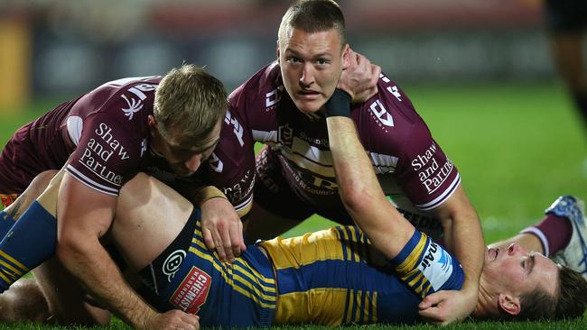 Nathan Brown is claimed by two Sea Eagles defenders.