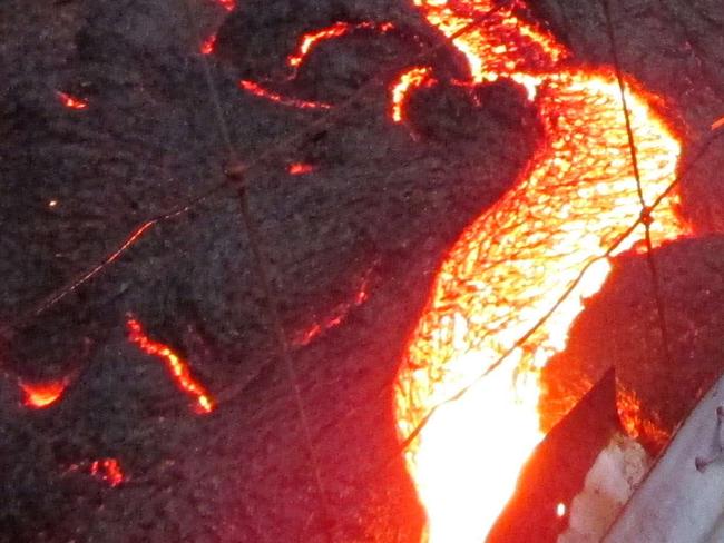 This image provided by the US Geological Survey (USGS) shows lava from the Kilauea volcano in Pahoa, Hawaii from the lobe that was active in the forest below the Pahoa cemetery overcomes a fence marking private property late on the afternoon of October 31, 2014. Red-hot lava from a slow-erupting volcano has reached a home on Hawaii's Big Island and is threatening an entire town, emergency officials said. The lava flow from the Kilauea volcano, burning everything in its path, had advanced some 90 yards (82 meters) in the past 24 hours towards the town of Pahoa, on the eastern tip of the island, officials said. AFP PHOTO / HANDOUT / US Geological Survey == RESTRICTED TO EDITORIAL USE / MANDATORY CREDIT: "AFP PHOTO / HANDOUT / US Geological Survey "/ NO MARKETING / NO ADVERTISING CAMPAIGNS / NO A LA CARTE SALES / DISTRIBUTED AS A SERVICE TO CLIENTS ==