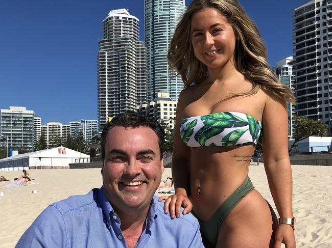 Jason Costigan posing with a bikini model on the Gold Coast.