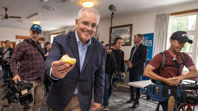 Prime Minister Scott Morrison proffers a buttered scone during a visit to the Longford RSL Memorial Club in Tasmania. Picture: Jason Edwards