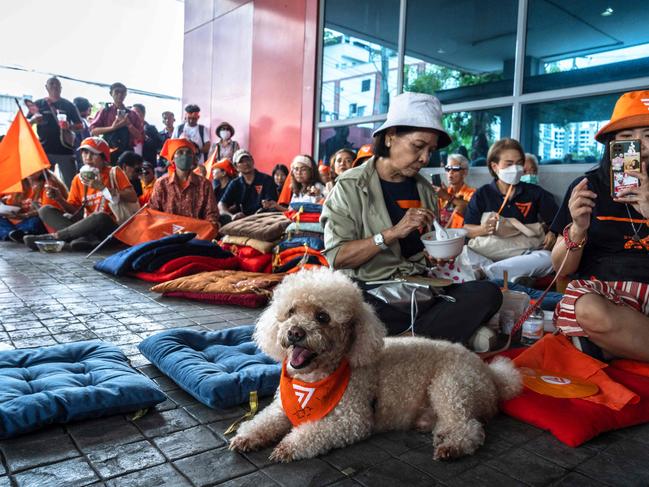 Supporters gather at the Move Forward Party (MFP) headquarters in Bangkok on August 7, 2024, as Thailand's Constitutional Court ruled whether former MFP leader Pita Limjaroenrat was to receive a decade-long ban and dissolve his party after challenging royal defamation laws. A popular Thai politician facing a decade-long ban after challenging royal defamation laws said he was "highly confident" of a ruling in his favour by Thailand's top court expected on August 7. (Photo by Chanakarn Laosarakham / AFP)