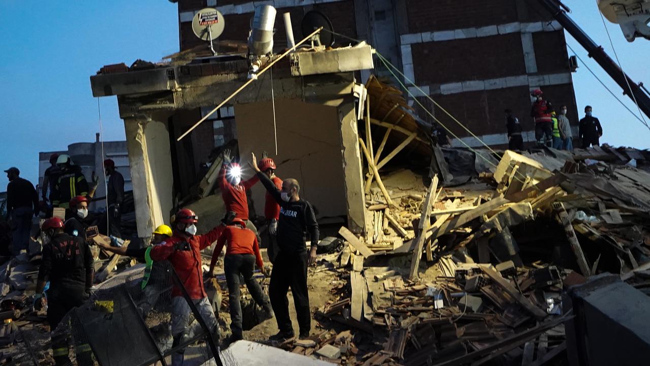 Emergency services personnel search a collapsed building for survivors after a powerful earthquake struck on Friday in Izmir. Picture: Getty Images.