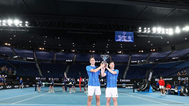 Finland's Harri Heliovaara (R) and Britain's Henry Patten (L) raised the trophy in front of a mostly empty stadium. (Photo by David GRAY / AFP) /