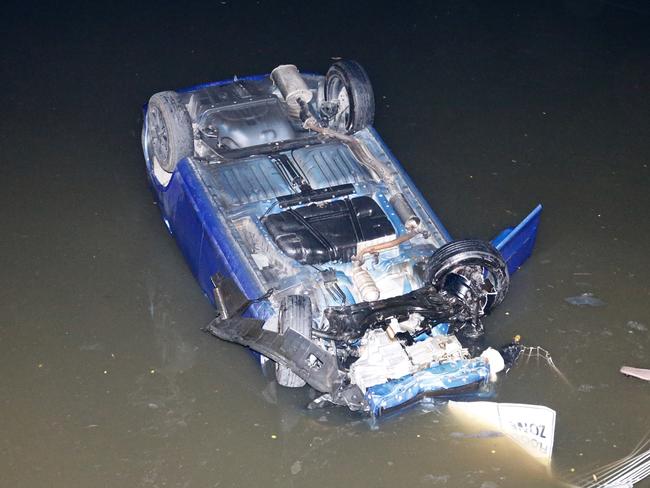 A honda jazz lies in several feet of water on its roof in the cooks river at Croydon park after itÃ¢â¬â¢s intoxicated driver lost control and sent it crashing through a metal fence into the river below  Picture : Steve Tyson  Time 0030 Location : Burwood road Croydon park