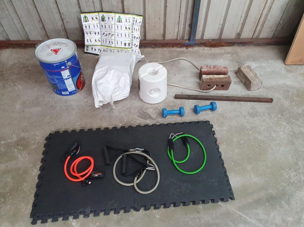 A Sydney gym junkie has used a paint tin, bricks and firewood to create his at-home gym. Picture: Supplied