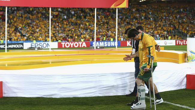 Robbie Kruse walks onto the ground after suffering a leg injury during the Asian Cup final.