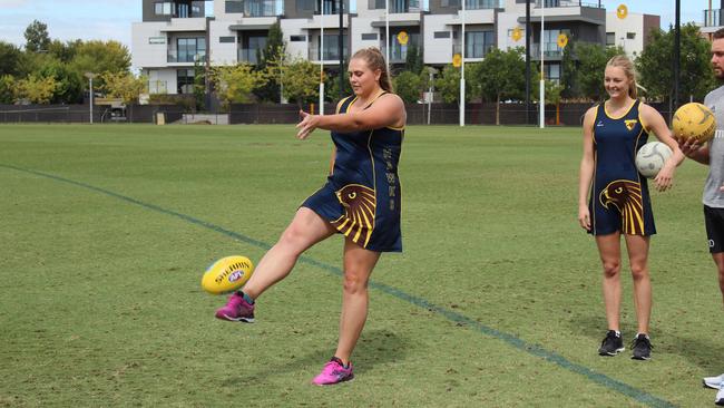 Hawks’ Kim Commane tries her hand with the oval ball.