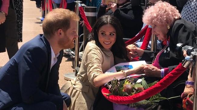 Britain's Prince Harry, the Duke of Sussex and his wife Meghan, the Duchess of Sussex meet with 98 year-old Daphne Dunne during a meet the people walk at the Sydney Opera House in Sydney, Australia, Tuesday, October 16, 2018. The Duke and Duchess of Sussex are on a 3-week tour of Australia, New Zealand, Tonga, and Fiji and are in Sydney to launch the 2018 Invictus Games, an Olympic-style event for disabled and ill service people. (AAP Image/Benita Kolovos) NO ARCHIVING