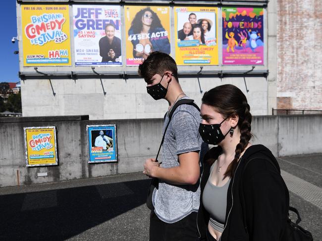 A masked couple walks in Brisbane yesterday. Picture: s of the state are in lockdown due to a cluster of the delta variant of the coronavirus. Picture: NCA NewsWire / Dan Peled