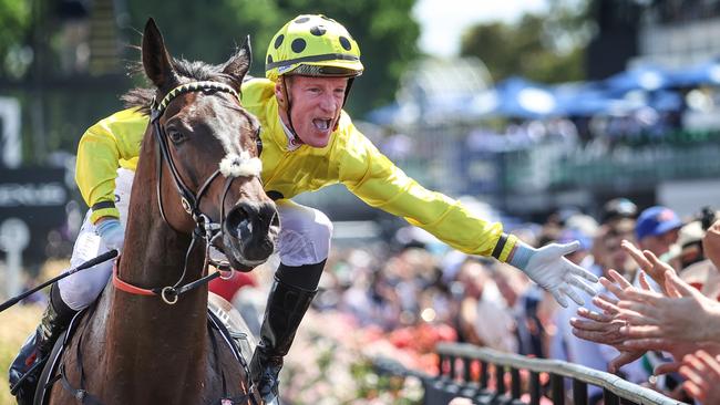 2023 Melbourne Cup Flemington. Running off the Melbourne Cup. Winning jockey Mark Zahra high fives the crowd on race horse Without A Fight on return to scale.     Picture: David Caird