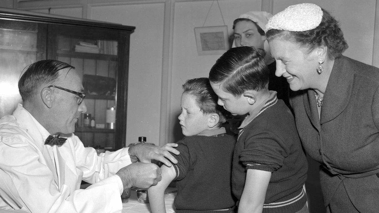 News. 18/6/1956 First shots of Salk anti-polio vaccine being given by Health and Medical Services deputy director Dr DW Johnson in Brisbane. On the receiving end are Clem, 7, left, and Paul, 9, sons of the Premier Vince Gair, pictured with their mother. Picture by Bob Millar jnr K8596 pub 19/6/56 The Courier-Mail Photo Archive.