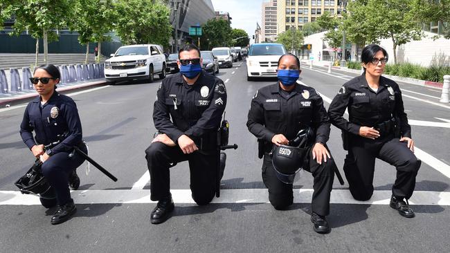 Los Angeles Police Department officers kneel during a rally led by Baptist Ministers to City Hall in memory of George Floyd on Wednesday. Picture: AFP)