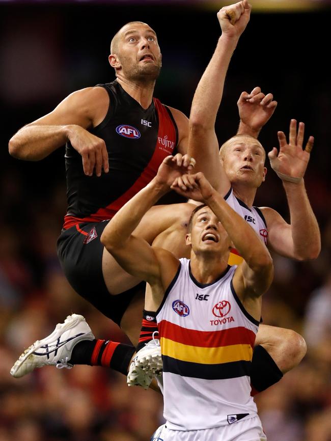 Tom Bellchambers of the Bombers flies above Crows players Tom Doedee and Sam Jacobs on Friday. Picture: Michael Willson/AFL Media/Getty Images