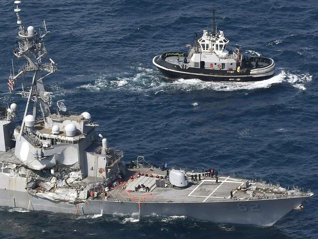 The crushed side of the USS Fitzgerald as the destroyer limps back to Yokosuka, home base of the 7th Fleet, beside a US tugboat. Picture: Kyodo News / AP