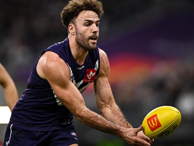 PERTH, AUSTRALIA - JULY 16: Griffin Logue of the Dockers handpasses the ball during the 2022 AFL Round 18 match between the Fremantle Dockers and the Sydney Swans at Optus Stadium on July 16, 2022 in Perth, Australia. (Photo by Daniel Carson/AFL Photos via Getty Images)