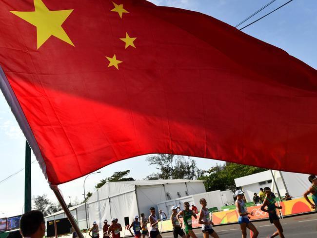 A Chinese national flag is displayed as athletes compete in the Men's 50km Race Walk during the athletics event at the Rio 2016 Olympic Games in Pontal in Rio de Janeiro on August 19, 2016.   / AFP PHOTO / Jewel SAMAD