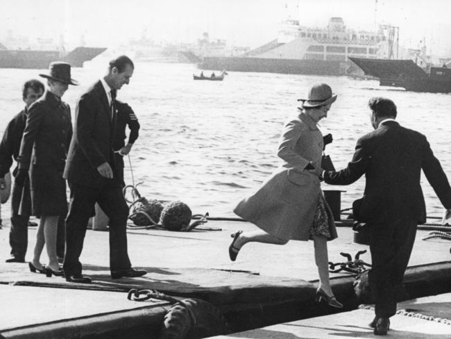 Queen Elizabeth II being helped ashore followed by Prince Philip during their Royal Visit to Australia in 1970.