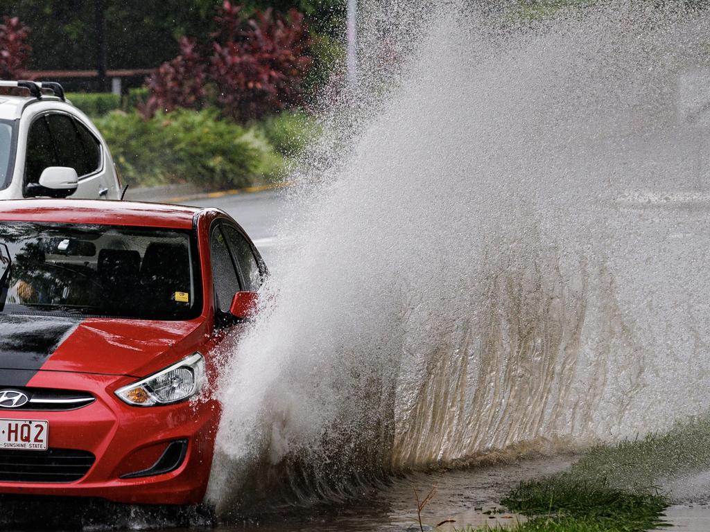 A car drives through flash flooding on Milton road on Tuesday. Picture Lachie Millard