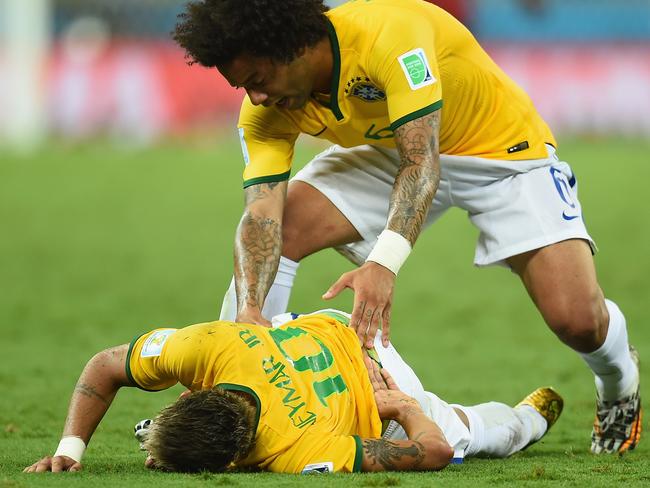 FORTALEZA, BRAZIL - JULY 04: Neymar of Brazil lies on the field after a challenge as teammate Marcelo reacts during the 2014 FIFA World Cup Brazil Quarter Final match between Brazil and Colombia at Castelao on July 4, 2014 in Fortaleza, Brazil. (Photo by Jamie McDonald/Getty Images)