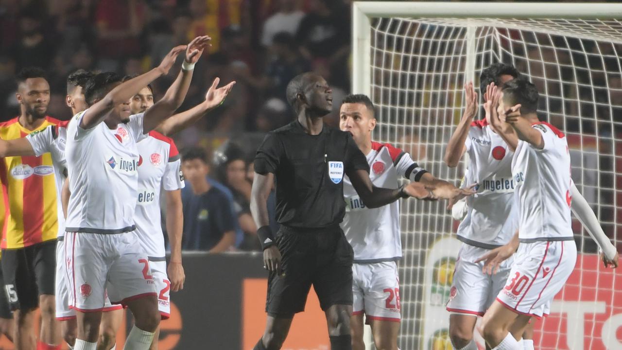 Wydad players ask the referee Gambian Bakary Papa Gassama (C) to check the goal