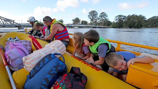 The Eggins family and their rescuers ducks as they approach a bridge across the Clarence River. Picture: Toby Zerna