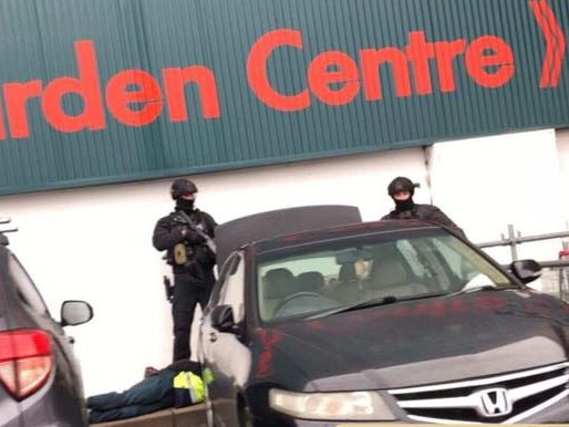 Riot stand over a man outside Bunnings Warehouse, Minchinbury on Wednesday. Picture: Lita Louise